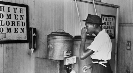 Colored Water Fountain - An African-American man drinks from a water fountain marked "colored" at a streetcar terminal in Oklahoma City, Oklahoma in 1939. PHOTOGRAPH BY BETTMANN - click for link to article