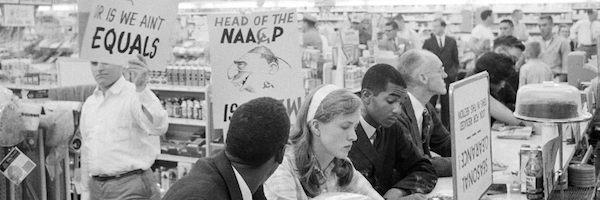 Demonstrators stage a sit-in at a drug-store lunch counter in Arlington, Virginia, while being picketed by American Nazi Party members on June 9, 1960. - Getty Images